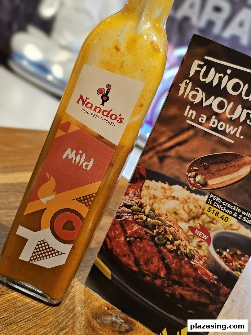 Nando's Mild PERi-PERi sauce bottle and a new chicken dish promotion.