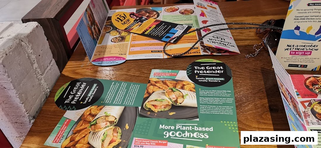 A wooden table at Nando's featuring various menus and promotional flyers.
