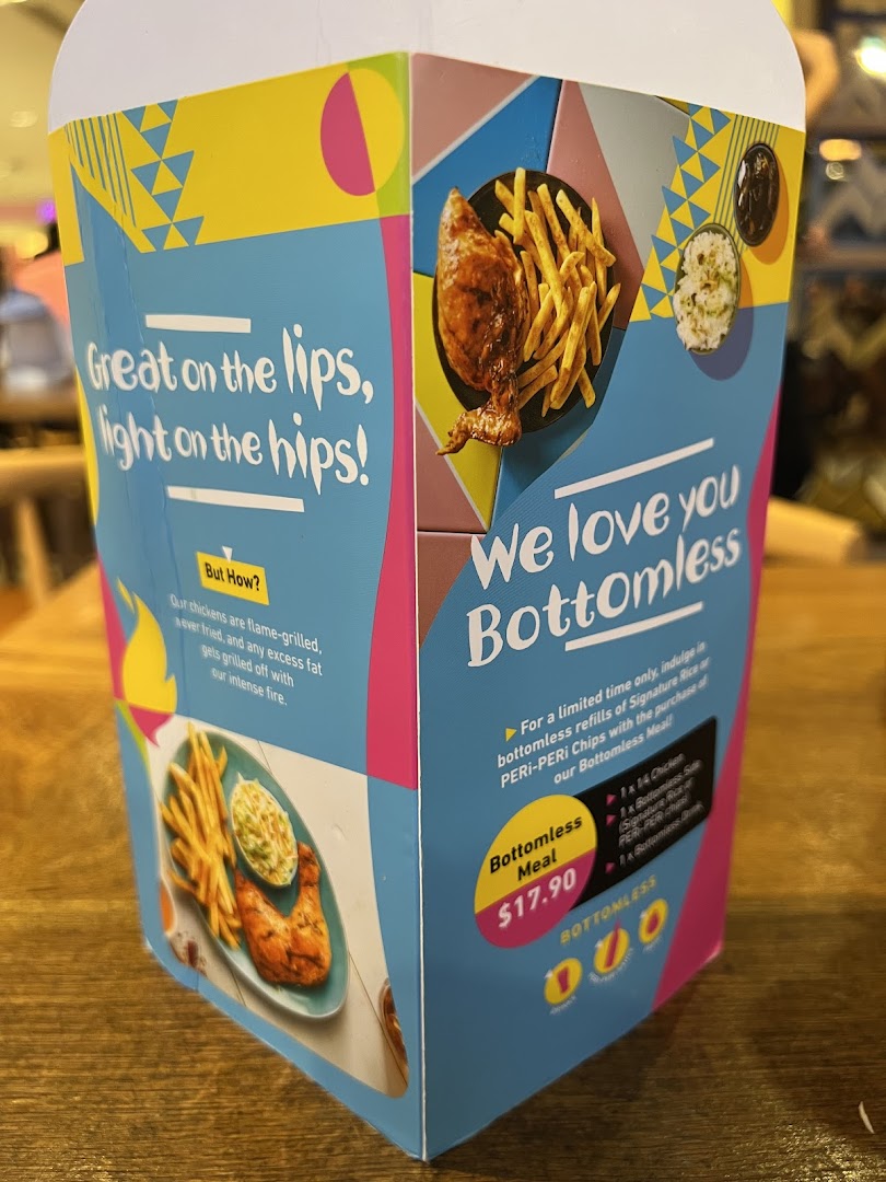 A promotional display for Nando's Bottomless Meal featuring flame-grilled chicken and sides.