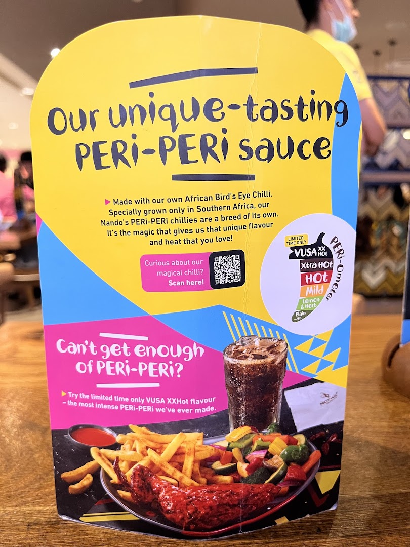 A Nando's table display promoting their unique PERi-PERi sauce and the new VUSA XXHot flavor.