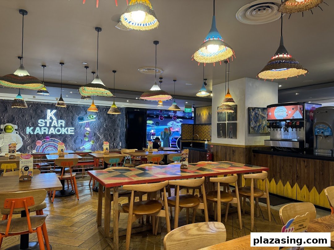 Vibrant interior of Nandos Plaza Singapura, featuring colorful decor, dining tables, and a K Star Karaoke sign.