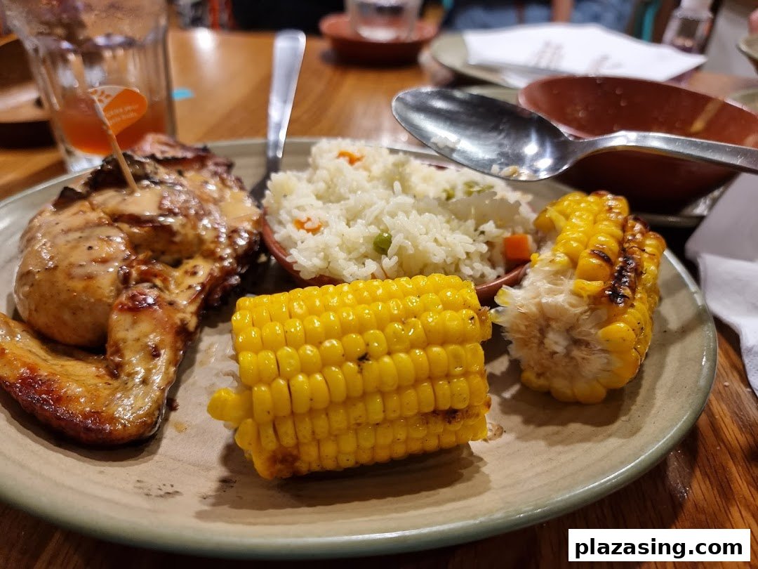 A delicious Nando's meal featuring flame-grilled PERi-PERi chicken, rice, and corn on the cob.