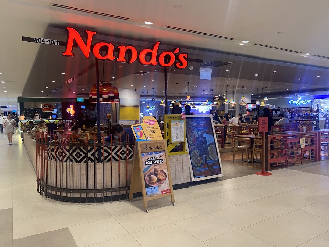 The vibrant Nando's restaurant entrance with its iconic red signage and inviting interior.
