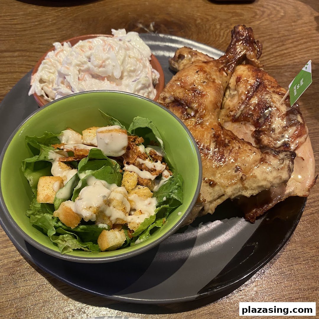 A plate of flame-grilled PERi-PERi chicken with creamy coleslaw and a fresh side salad.
