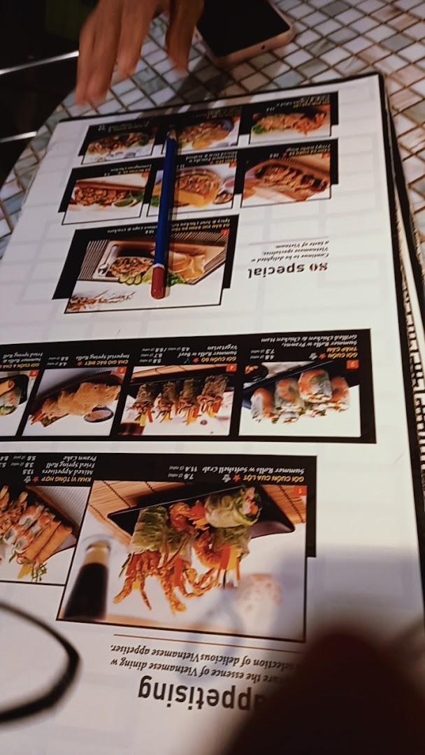 A close-up view of a Vietnamese restaurant menu displaying various appetisers and rolls.