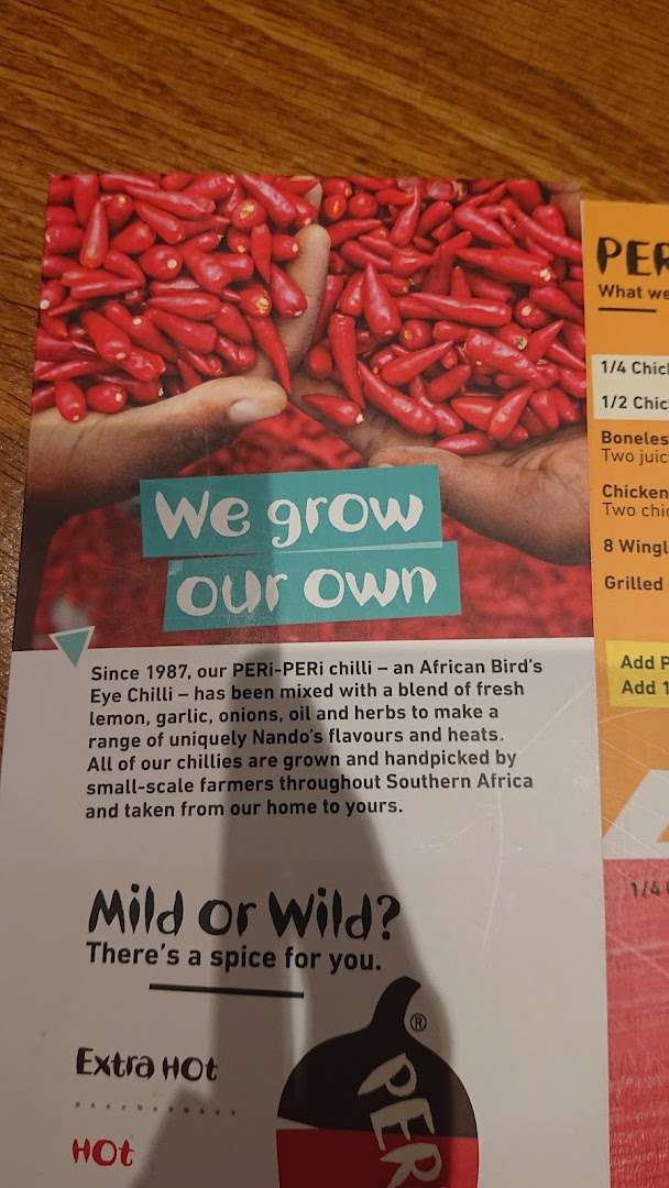 A Nando's menu page highlighting their PERi-PERi chilli sourcing and heat levels, with partial menu items.