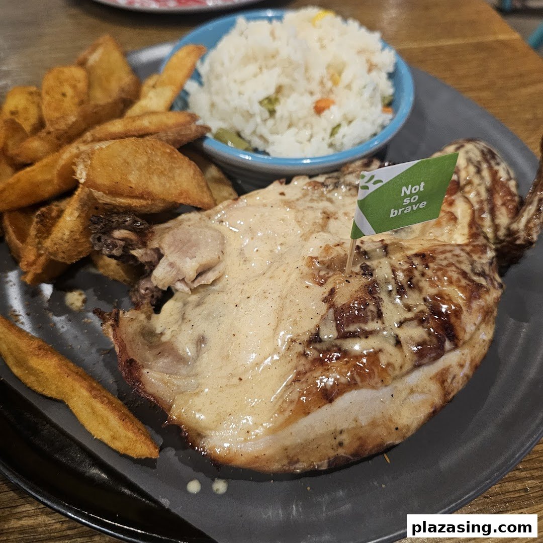 A plate of flame-grilled PERi-PERi chicken with potato wedges and rice.