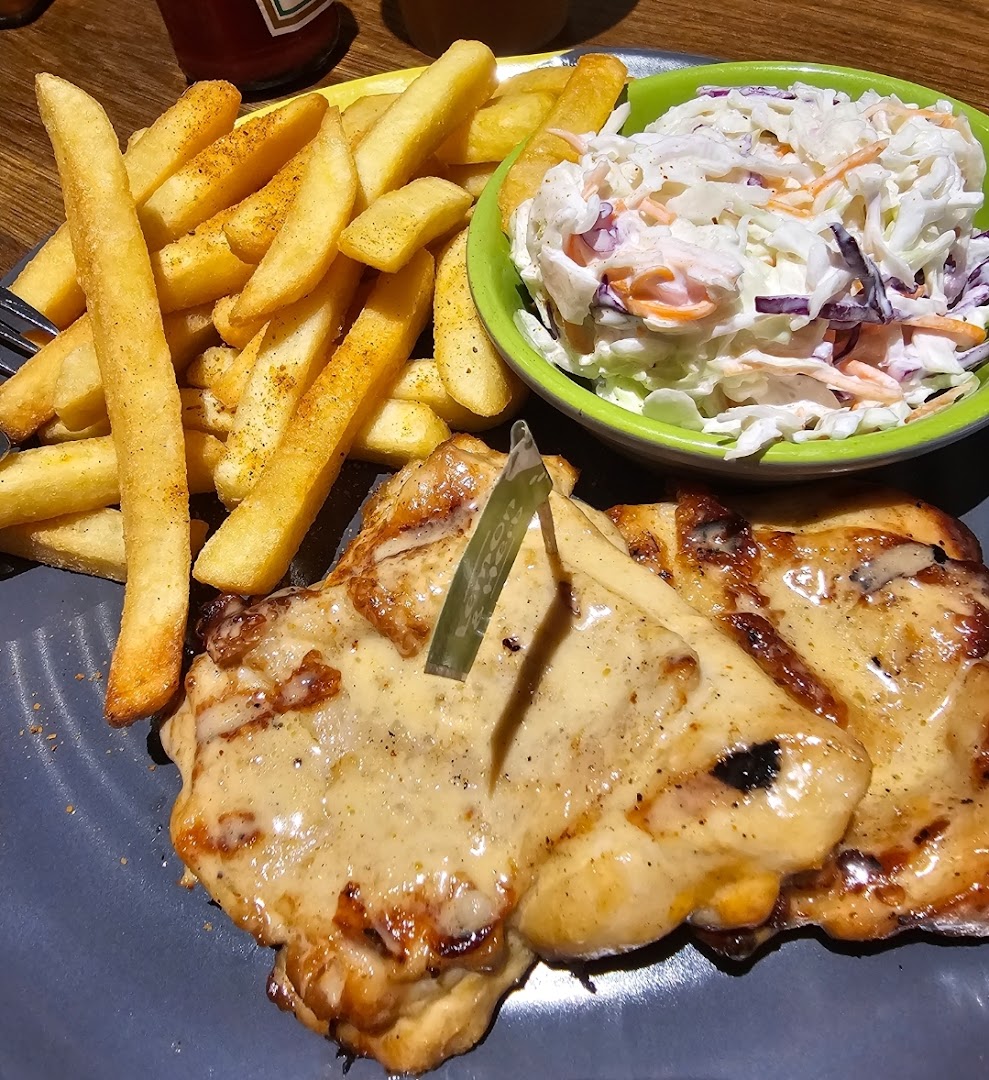 A delicious Nando's meal featuring flame-grilled chicken, crispy fries, and fresh coleslaw.