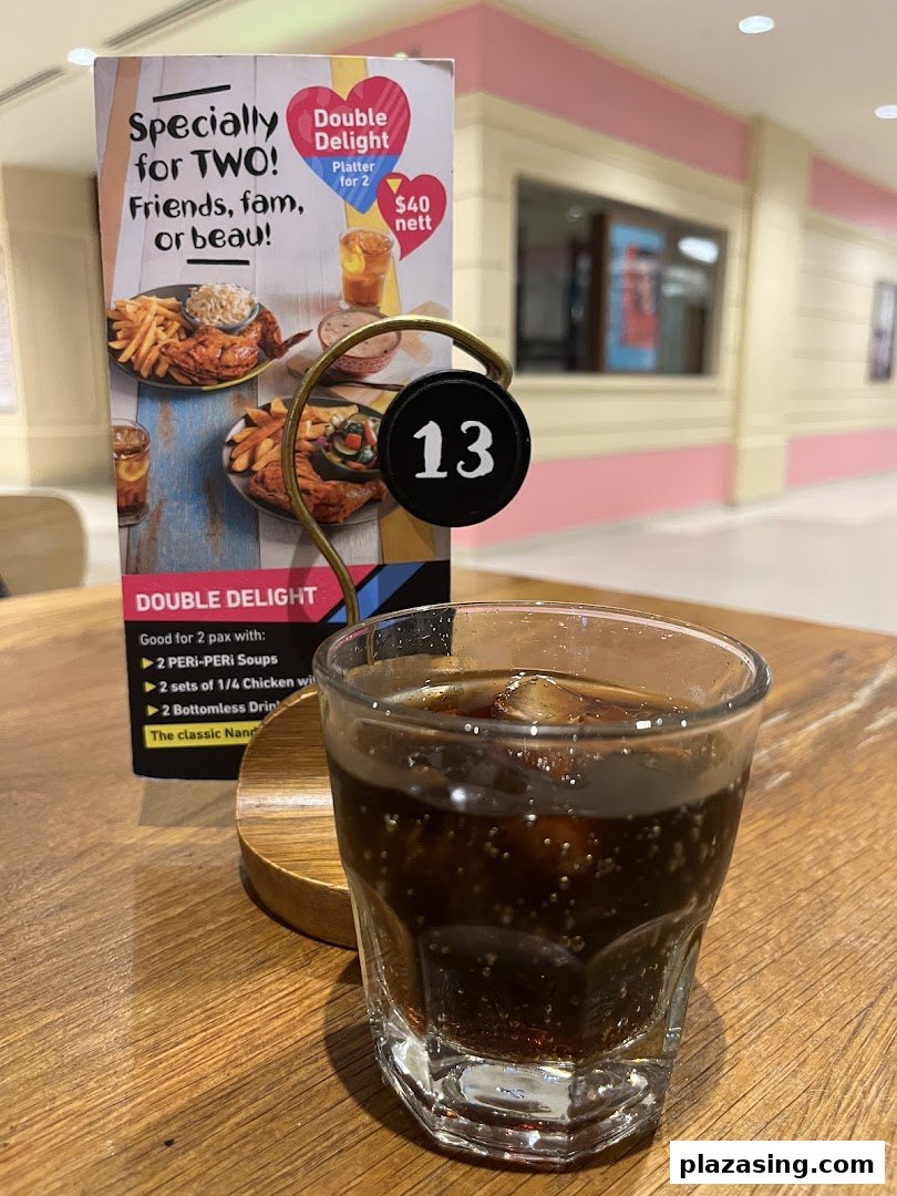 A Nando's table tent promoting the 'Double Delight' platter with a drink.