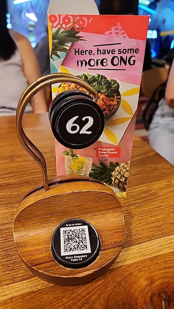 A Nando's table with a number stand, QR code for ordering, and a promotional drink card.