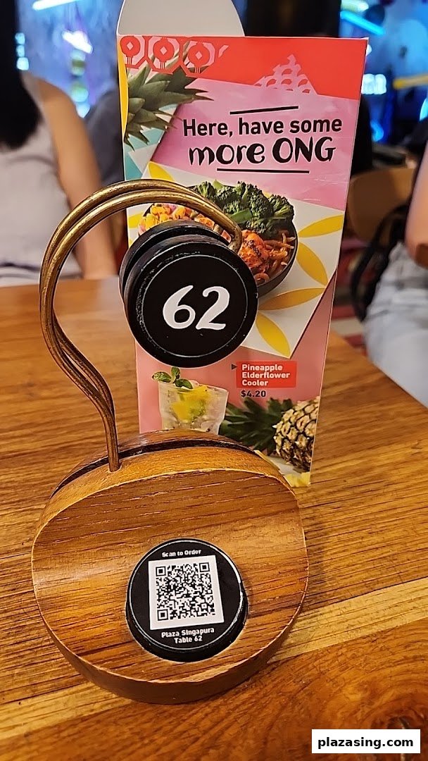 A Nando's table with a number stand, QR code for ordering, and a promotional drink card.