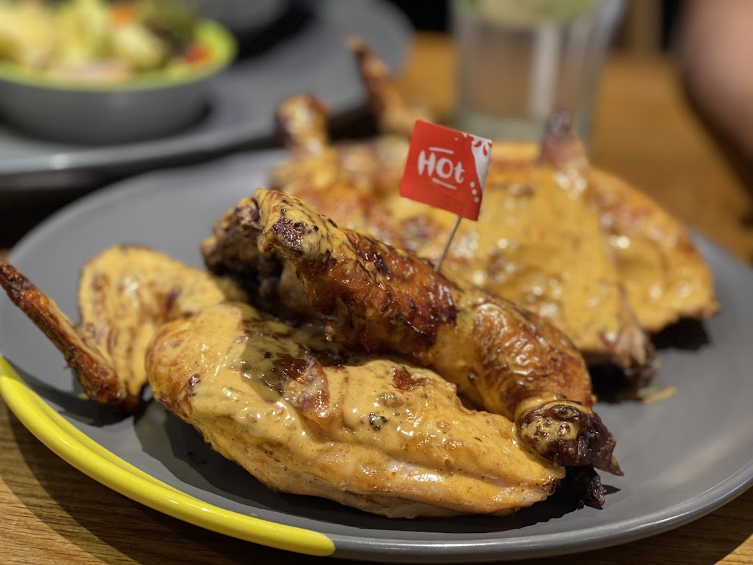 Close-up of Nando's flame-grilled PERi-PERi chicken with a 'Hot' spice flag.