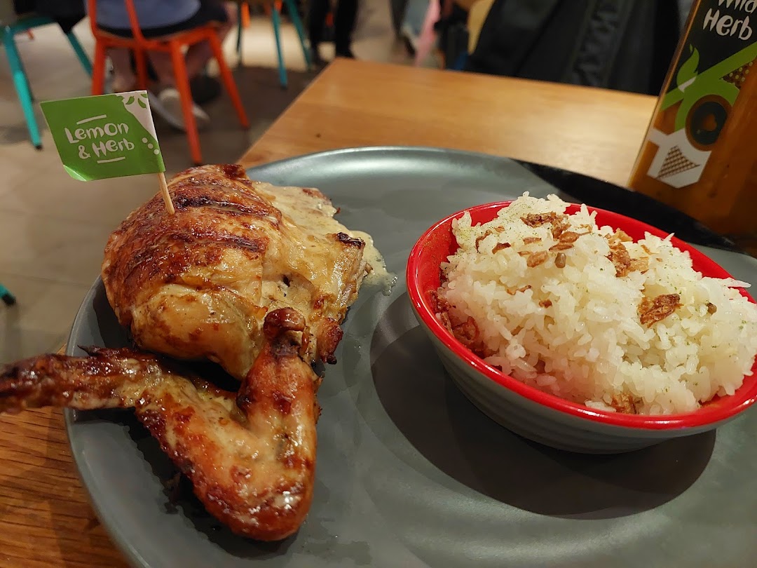 A plate of Nando's flame-grilled PERi-PERi chicken with Lemon & Herb flavor and a side of rice.