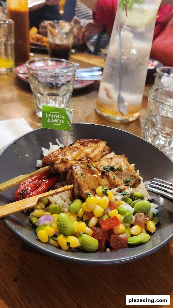 A delicious Nando's Lemon & Herb chicken skewer bowl with rice and vibrant salad.