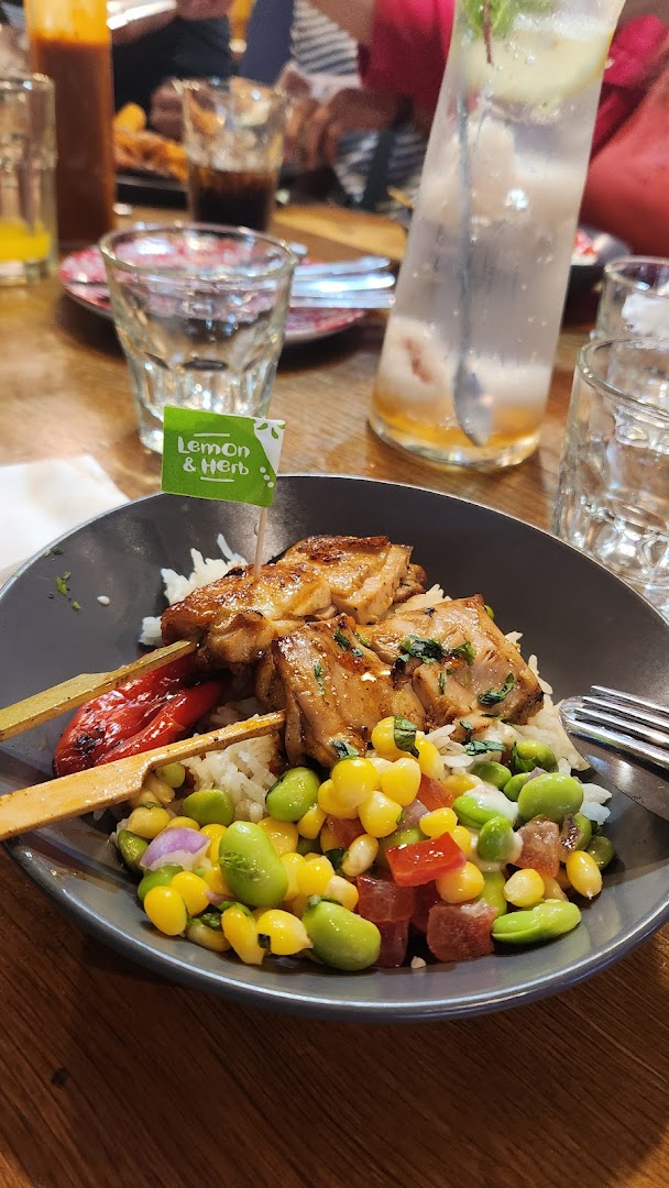 A delicious Nando's Lemon & Herb chicken skewer bowl with rice and vibrant salad.