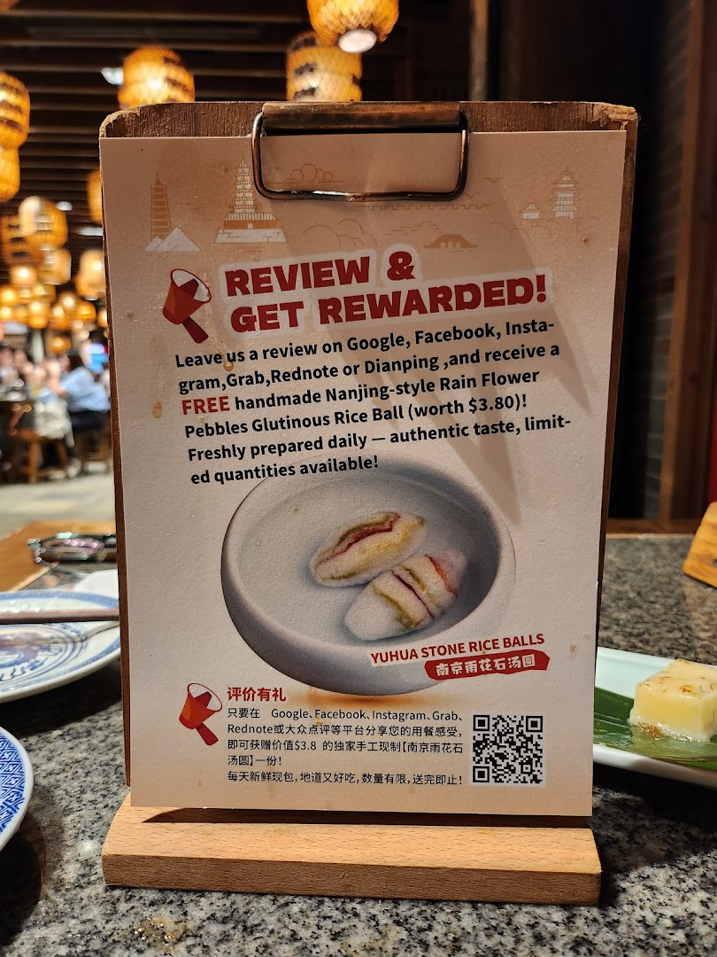 A promotional sign in Nanjing Impressions offering a free dessert for customer reviews.