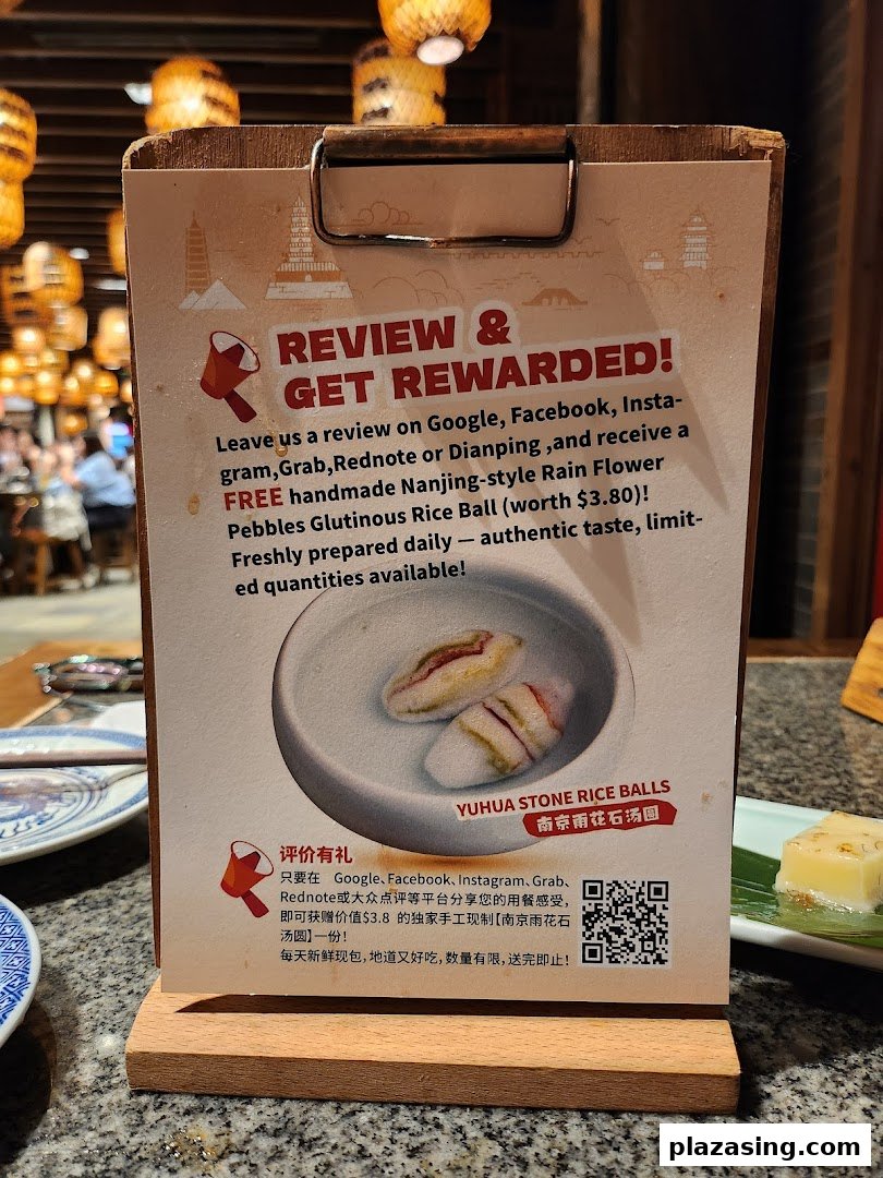 A promotional sign in Nanjing Impressions offering a free dessert for customer reviews.