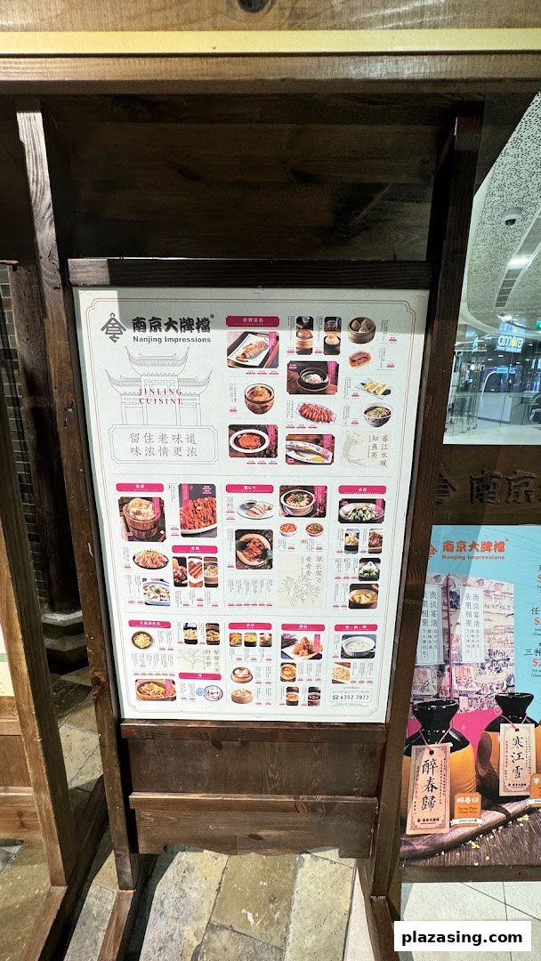 A wooden stand displaying a large promotional menu board for Nanjing Impressions restaurant, featuring various Jinling cuisine dishes.