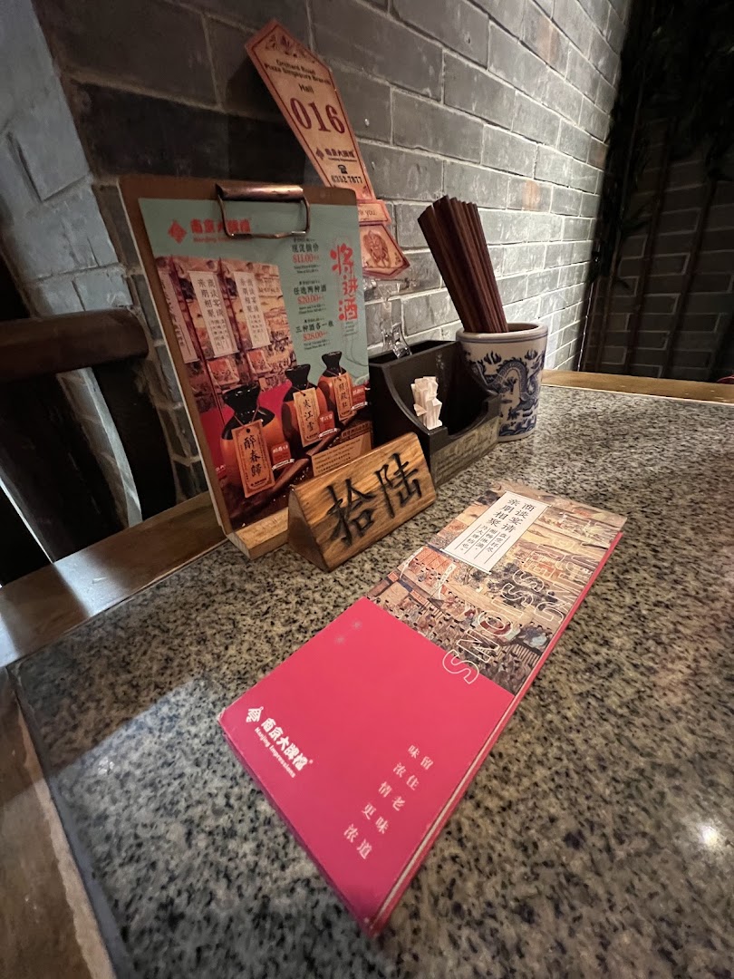 A table setting at Nanjing Impressions featuring a clipboard menu and chopsticks.