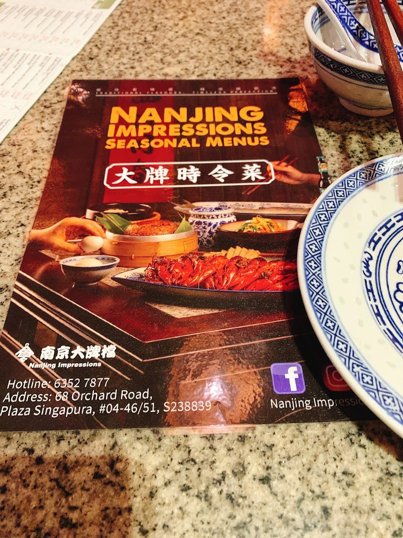 A close-up of the Nanjing Impressions Seasonal Menus cover on a dining table.