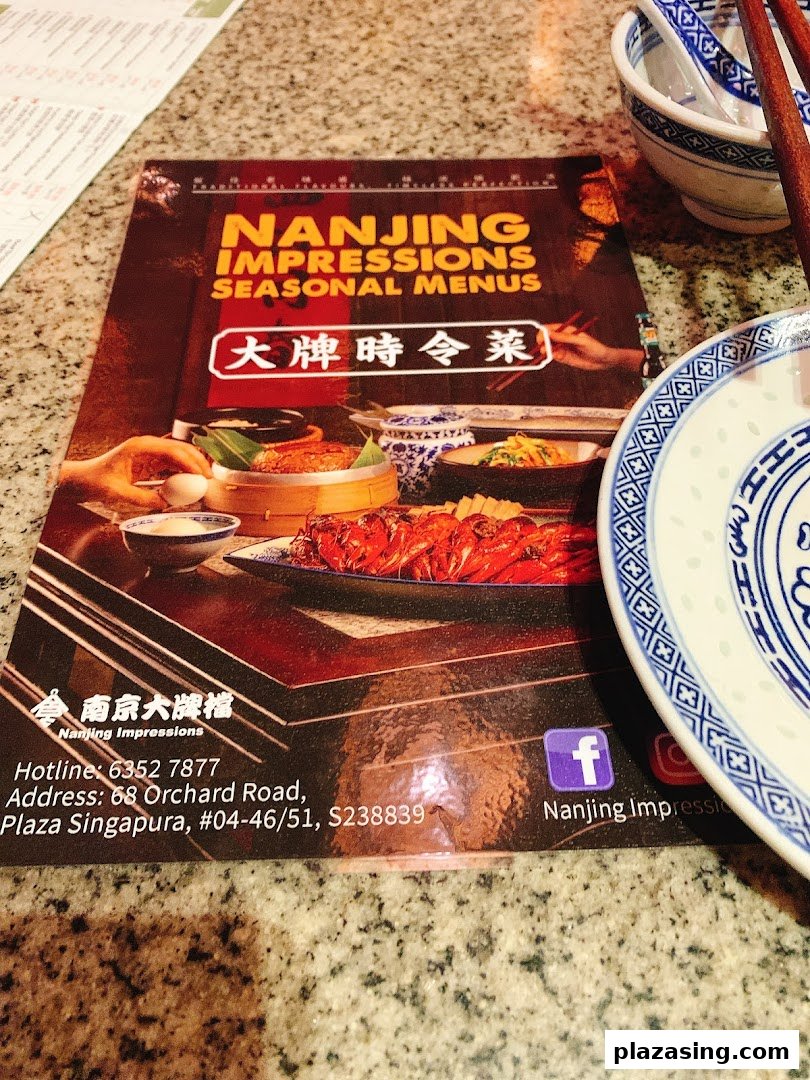 A close-up of the Nanjing Impressions Seasonal Menus cover on a dining table.
