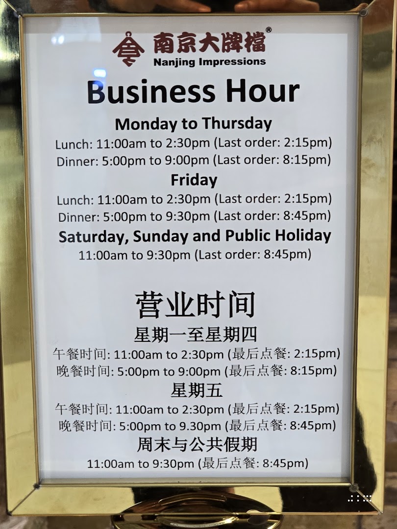 A sign displaying the detailed business hours for Nanjing Impressions restaurant.