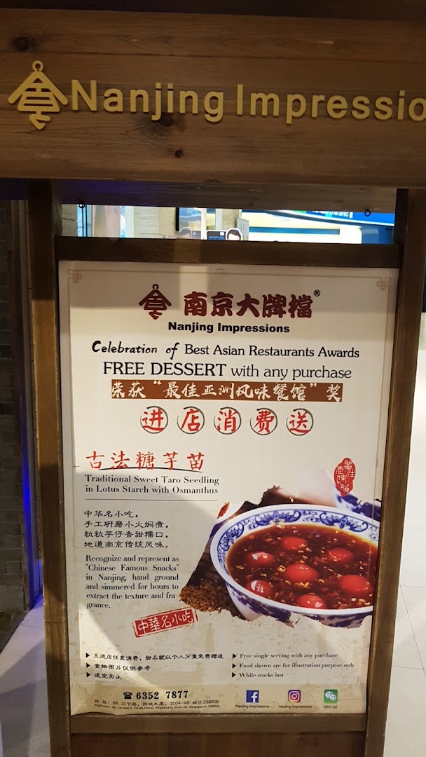A promotional standee for Nanjing Impressions, featuring a free dessert offer and a traditional taro dish.