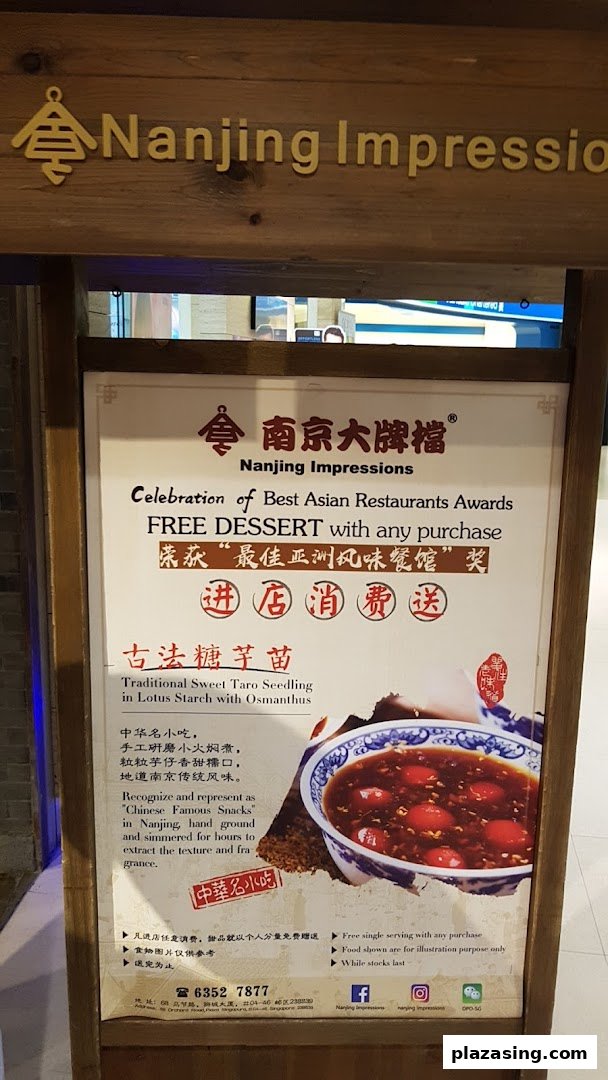 A promotional standee for Nanjing Impressions, featuring a free dessert offer and a traditional taro dish.