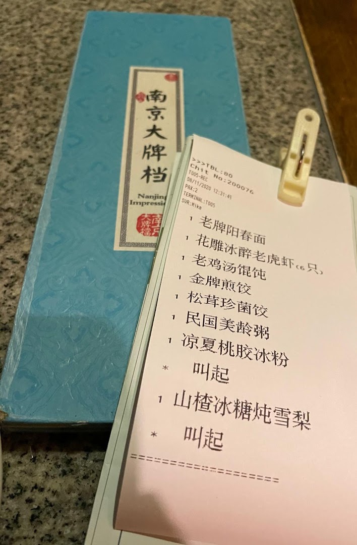 A close-up of a restaurant order slip featuring a selection of traditional Nanjing dishes.