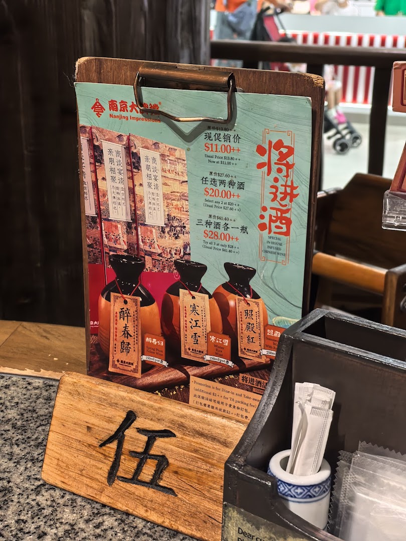 A menu board displaying promotions for in-house infused Chinese wines at Nanjing Impressions.