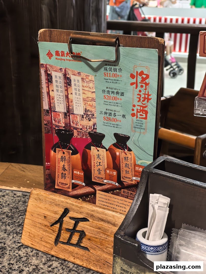 A menu board displaying promotions for in-house infused Chinese wines at Nanjing Impressions.