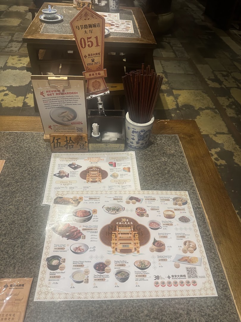 A restaurant table setting featuring menus, chopsticks, and a table number display.