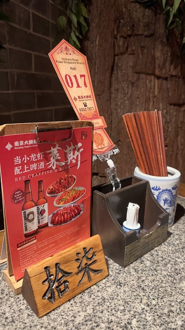 A table setting at Nanjing Impressions featuring a promotional flyer for crayfish and beer.