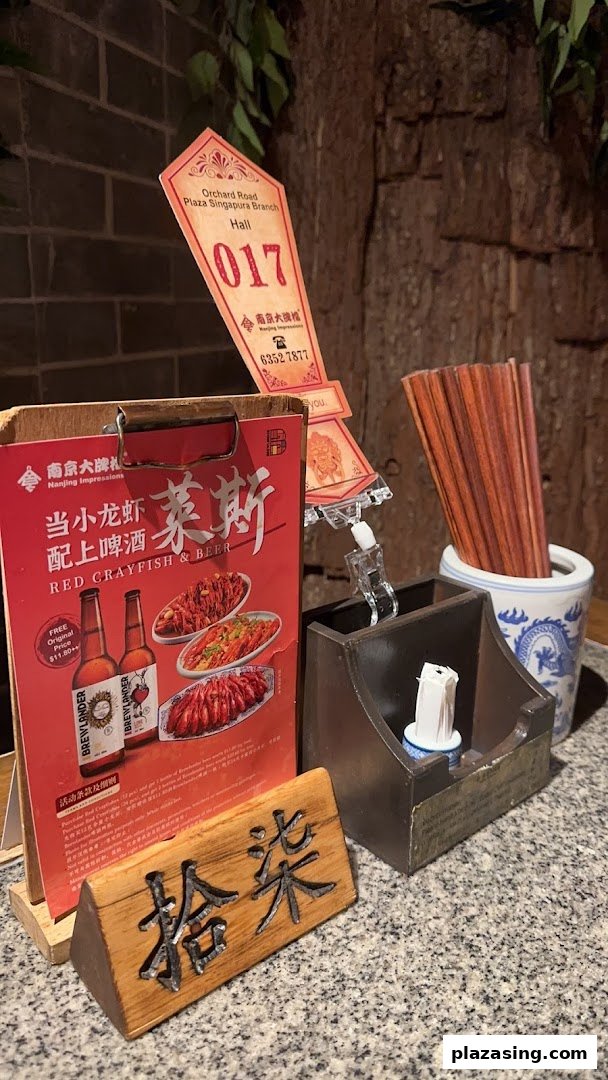 A table setting at Nanjing Impressions featuring a promotional flyer for crayfish and beer.