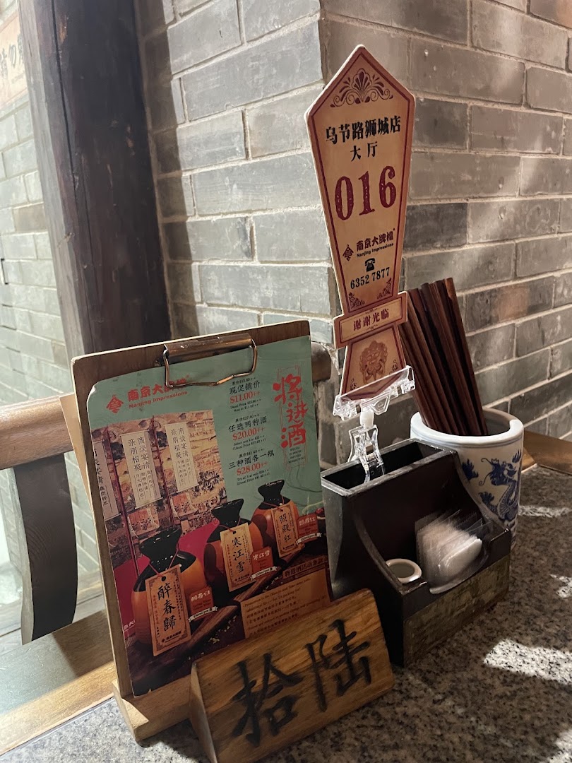 A table setting featuring a promotional menu for traditional Chinese wines at Nanjing Impressions.