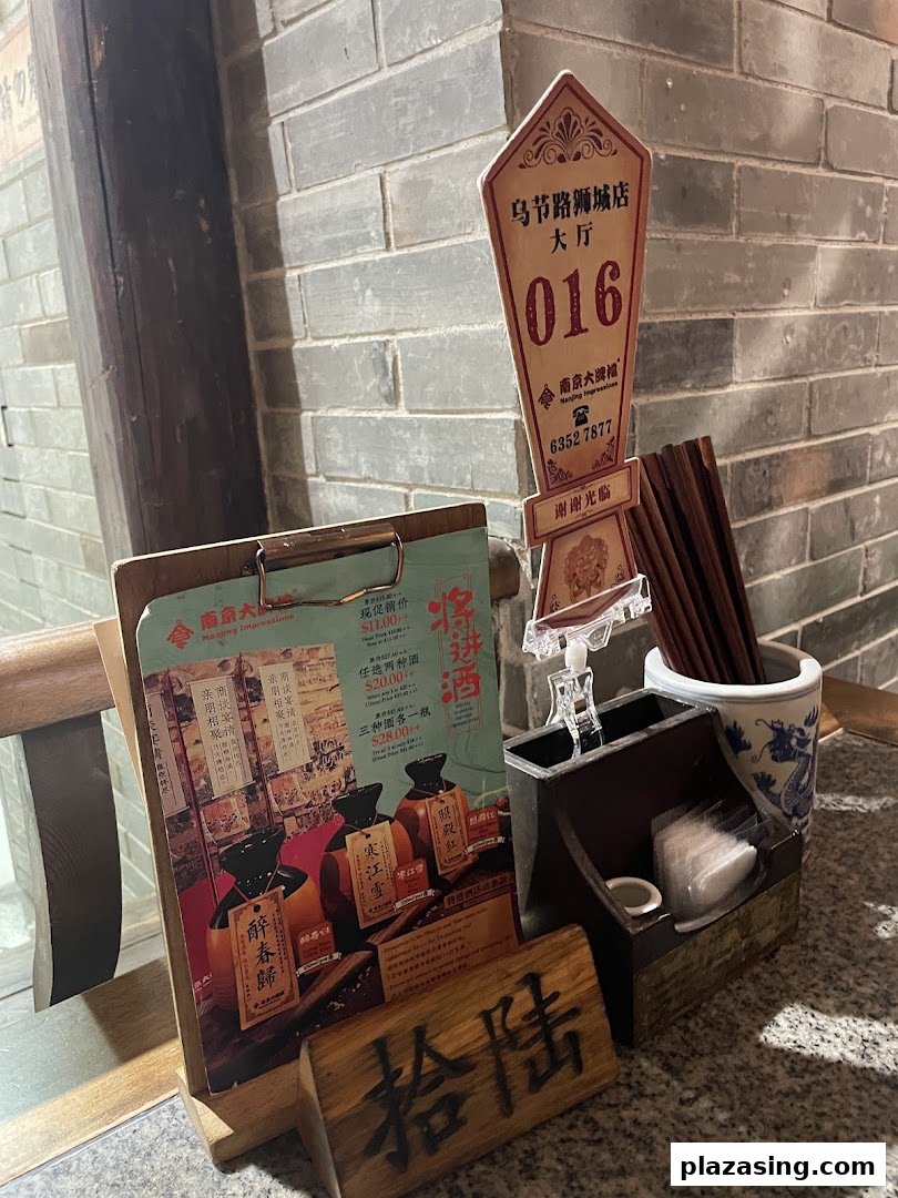 A table setting featuring a promotional menu for traditional Chinese wines at Nanjing Impressions.