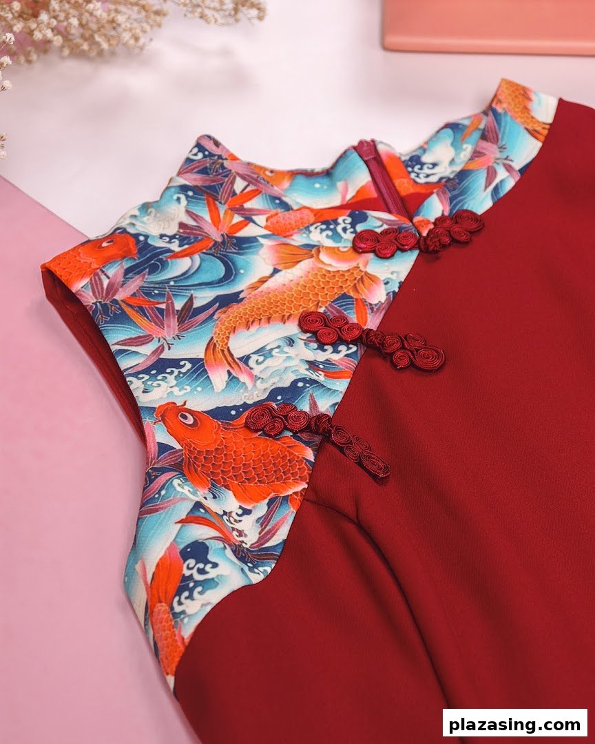 Close-up of a red dress featuring a vibrant koi fish pattern and traditional frog closures.