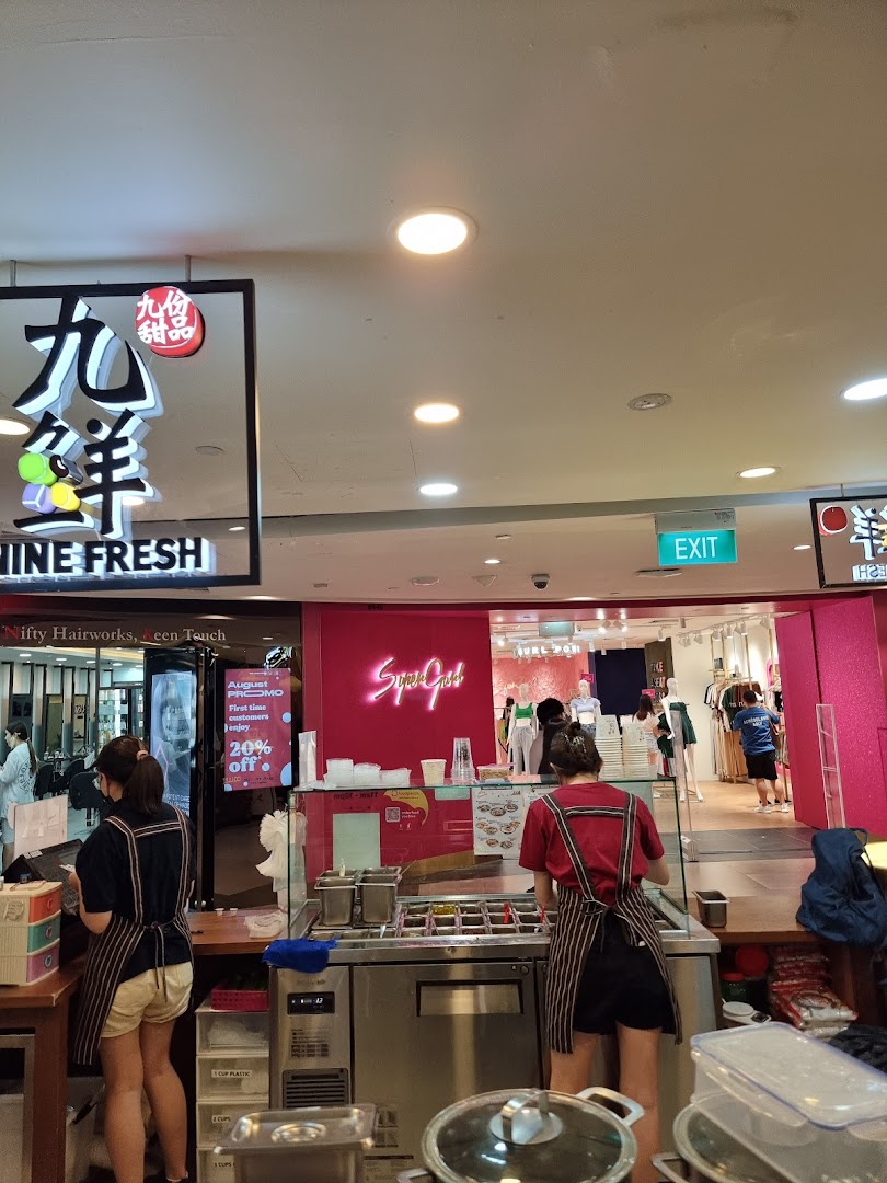 Two staff members prepare fresh desserts behind a counter at Nine Fresh Desserts Taiwan.