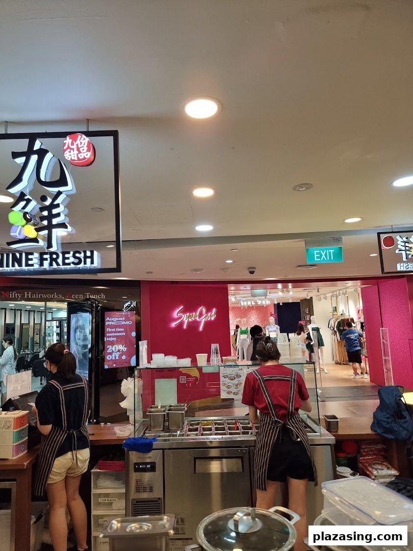Two staff members prepare fresh desserts behind a counter at Nine Fresh Desserts Taiwan.