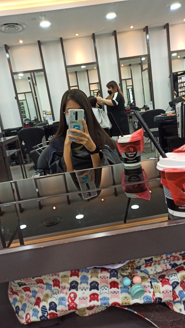 A customer takes a mirror selfie while getting their hair styled at NK Hairworks.