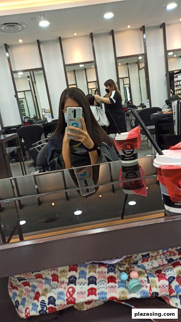 A customer takes a mirror selfie while getting their hair styled at NK Hairworks.