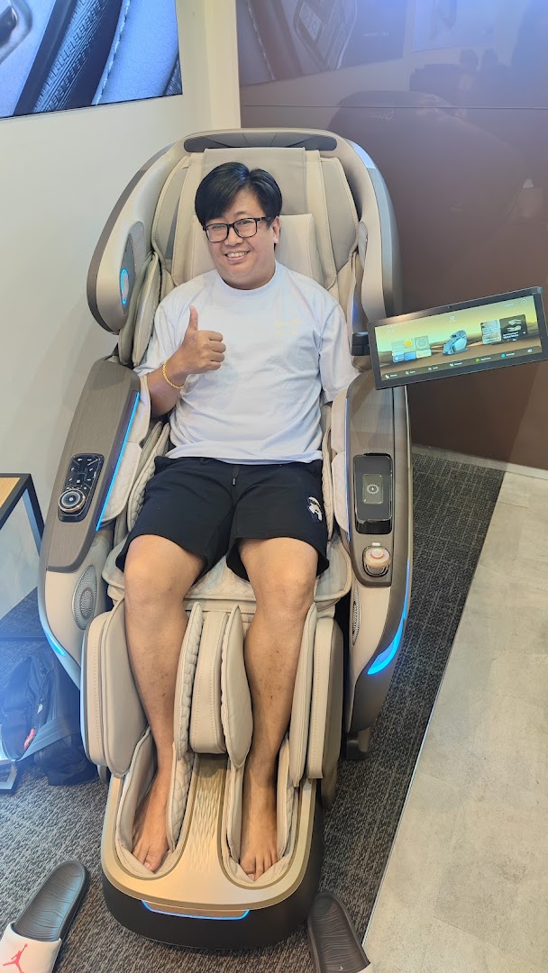 A smiling man gives a thumbs-up while relaxing in a modern massage chair at OGAWA.
