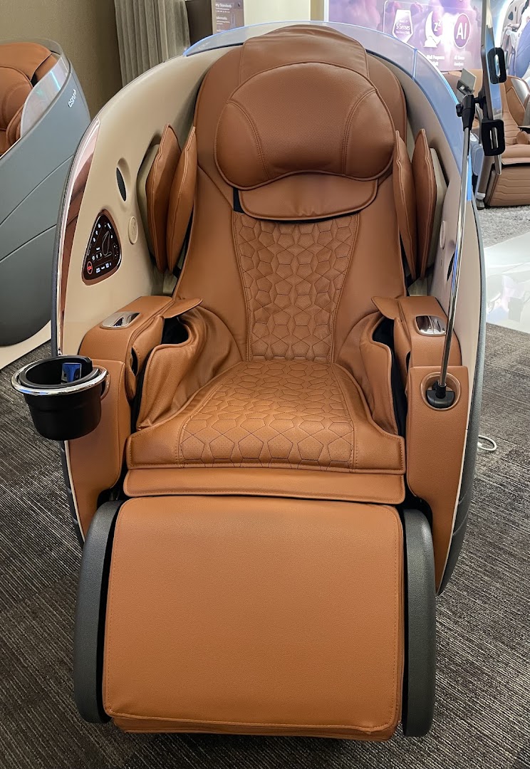 A luxurious brown OSIM massage chair with intricate detailing and a cup holder.