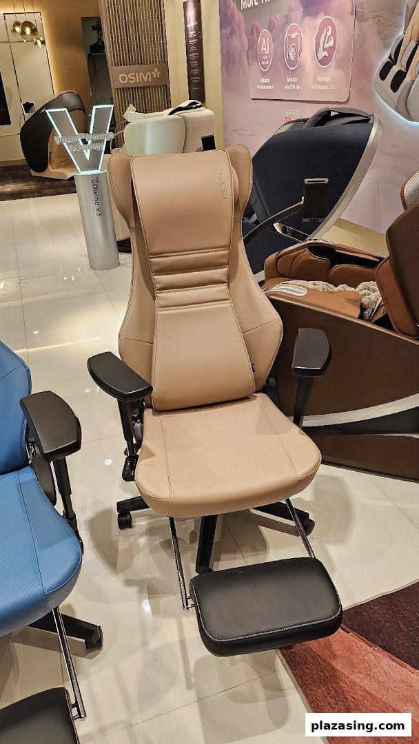 A beige massage chair with a footrest displayed in the OSIM shop, surrounded by other wellness products.
