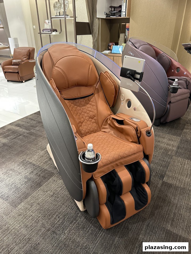 A luxurious brown massage chair with a tablet and water bottle in an OSIM store.