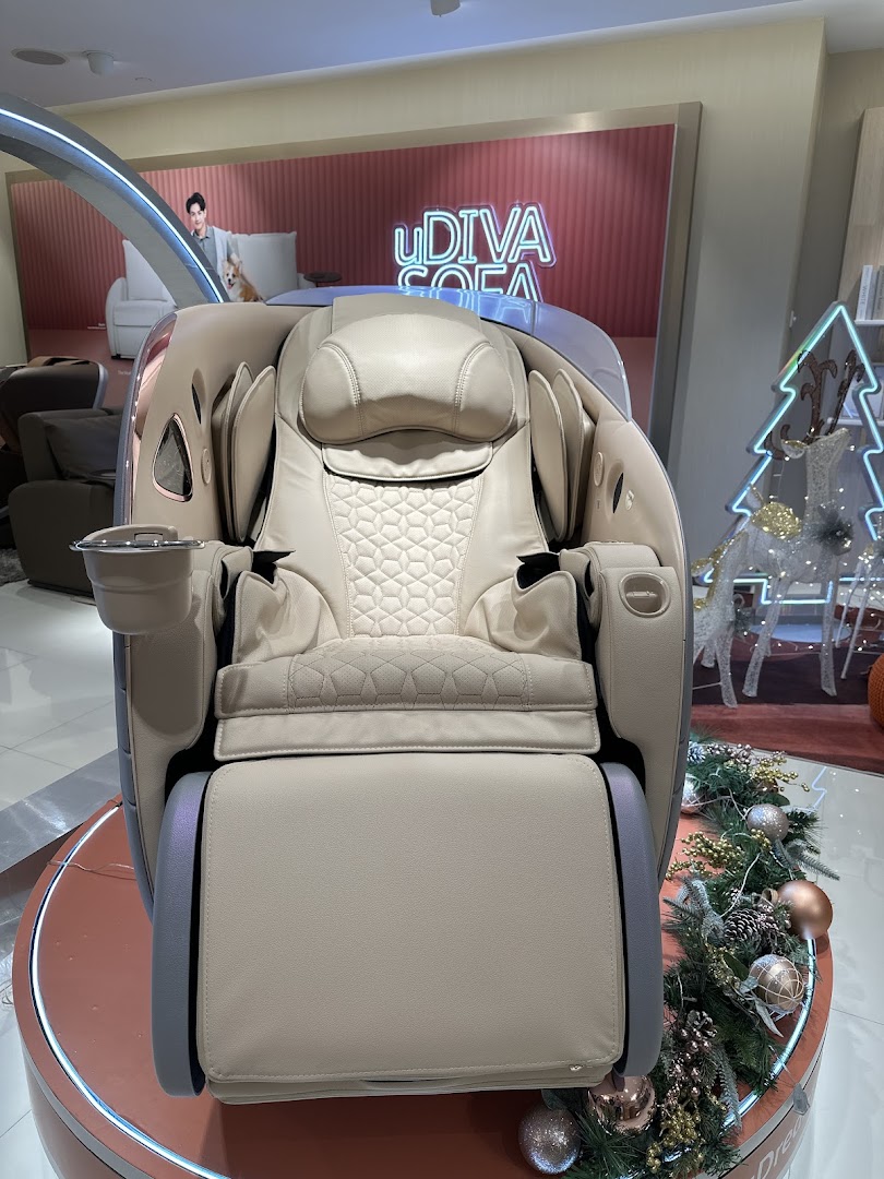 A luxurious beige massage chair displayed in an OSIM store, surrounded by festive decorations.