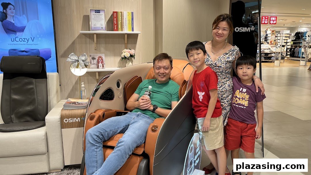 A family enjoys trying out massage chairs and wellness products inside an OSIM store.
