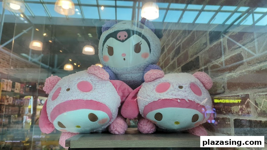Three large plush toys, including a Kuromi and two pink pig-like characters, displayed in a shop window.