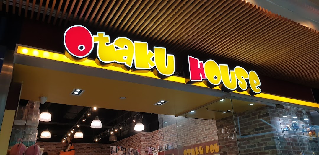The vibrant yellow and red illuminated storefront of Otaku House at Plaza Singapura.