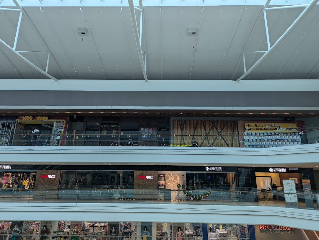 View of Otaku House and other shops on upper levels of Plaza Singapura mall, featuring anime gacha capsules.